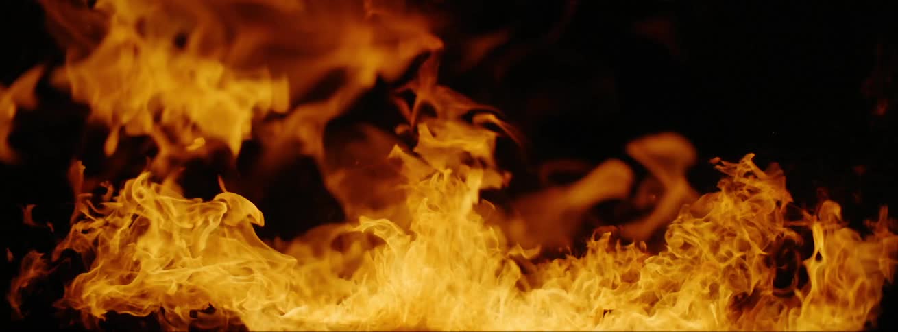 A log burning with violent orange and yellow flames at night