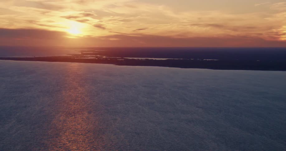 An aerial view of the sun setting over a lake
