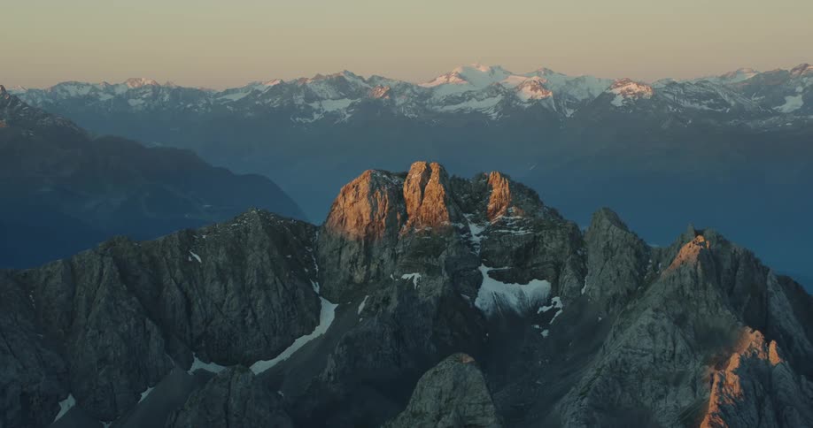 A snow and ice covered mountain range with the sky and clouds in the background