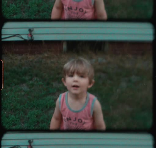 A little boy plays in the yard with toys during the summer