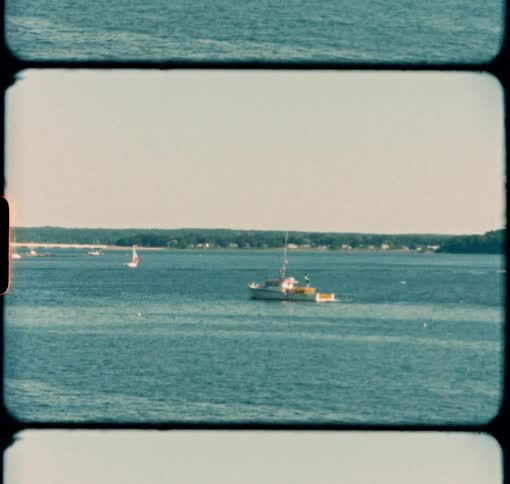 A lobster boat travels along the Maine coastline during the summer