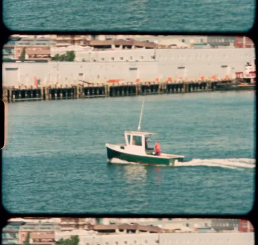 A small fishing boat sails toward the port city of Portland Maine