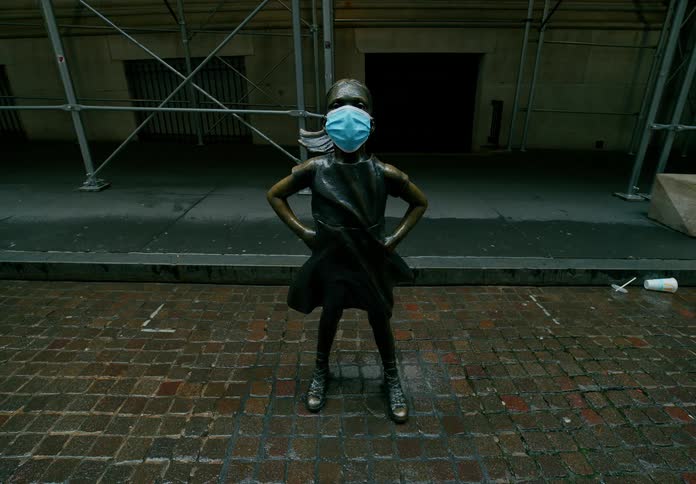 A statue of a little girl with a medical mask placed over its face