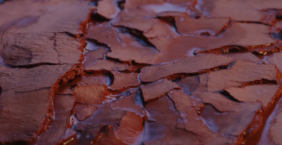 Water underneath cracked red rock dries up