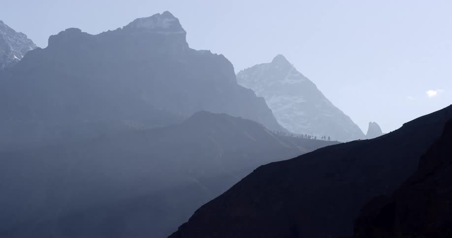 Mountain peaks shrouded in fog under a clear sky