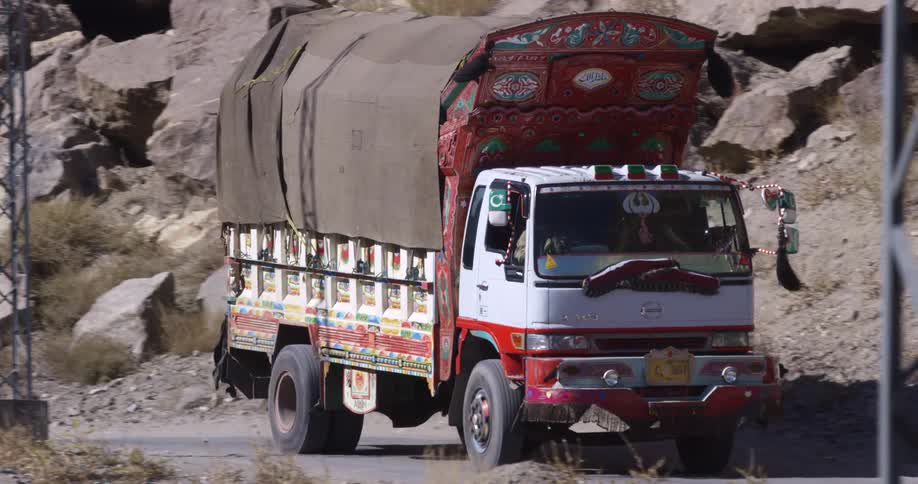 A shipping truck travels on a mountain road