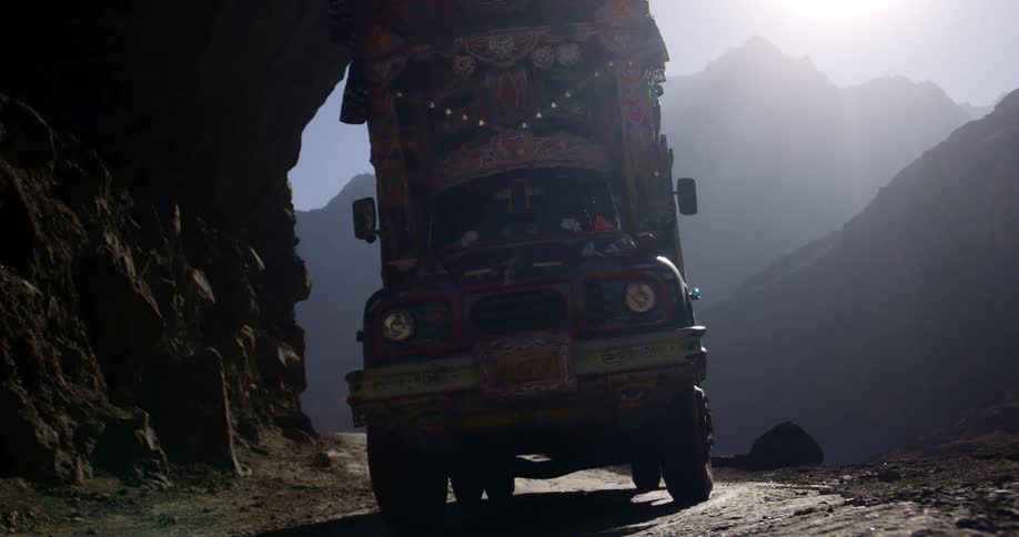 Decorated painted bus driving on a mountain road