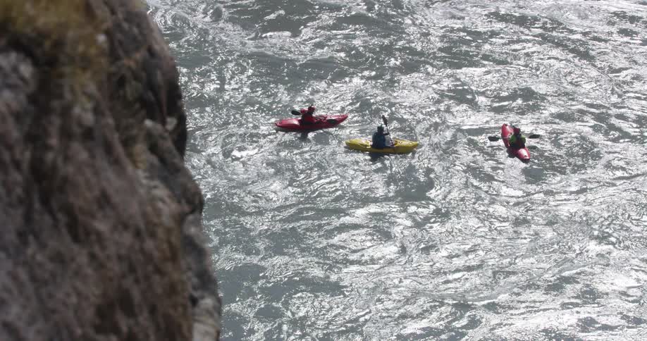 Three people kayaking on a river