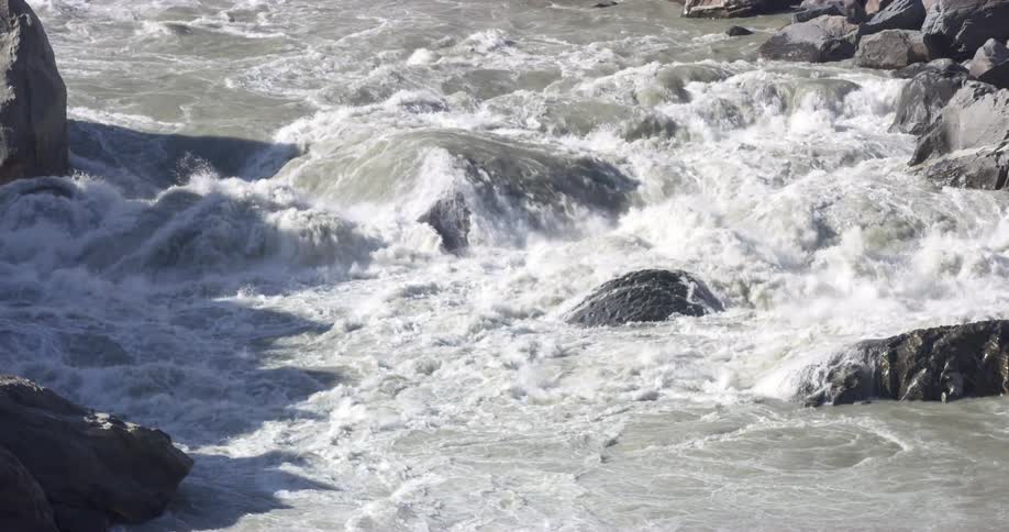 Whitewater river water flows round and over large boulders