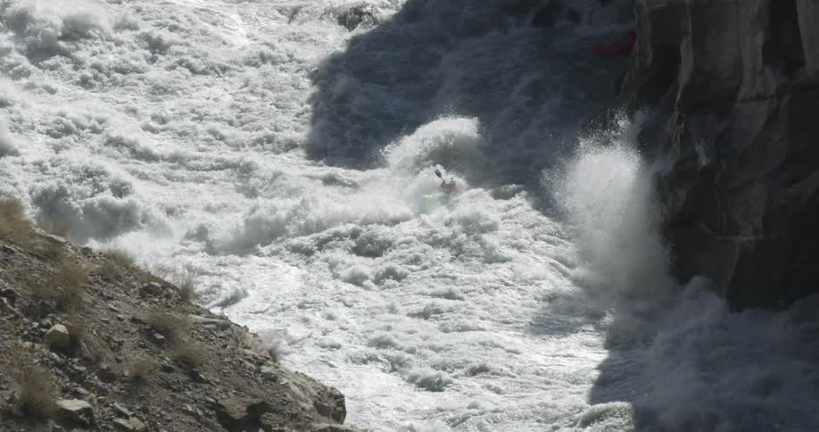 A person kayaking through river rapids