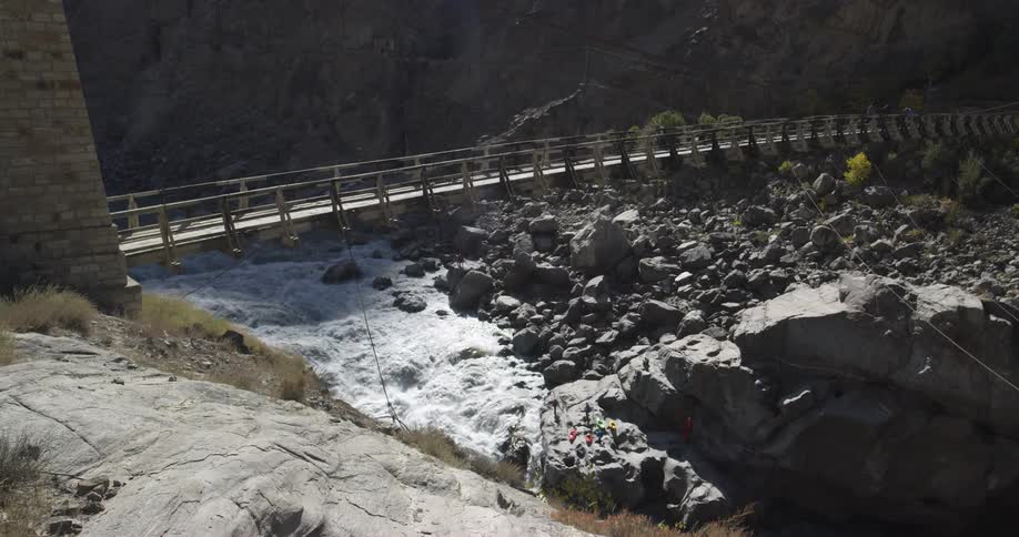 A narrow bridge over a river on a sunny day
