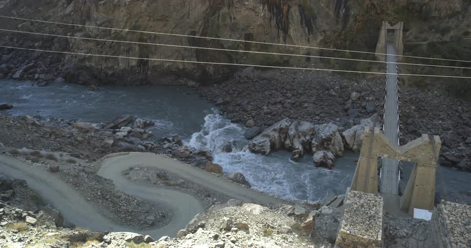 A dirt road next to a river a bridge and a tunnel