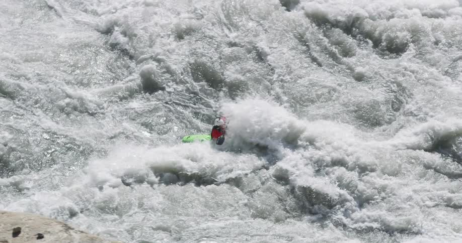 A person with a canoe and a paddle going down a river with rocks