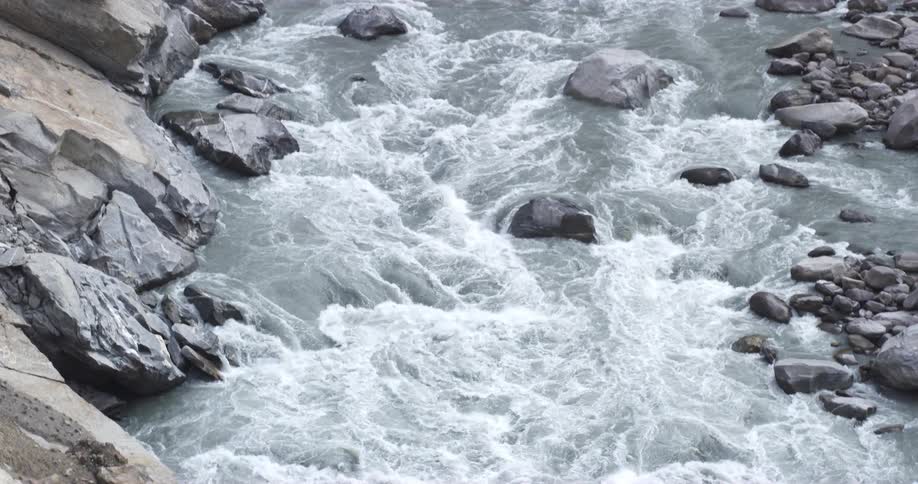 Water flowing in a river passes over some rocks which forms dangerous rapids