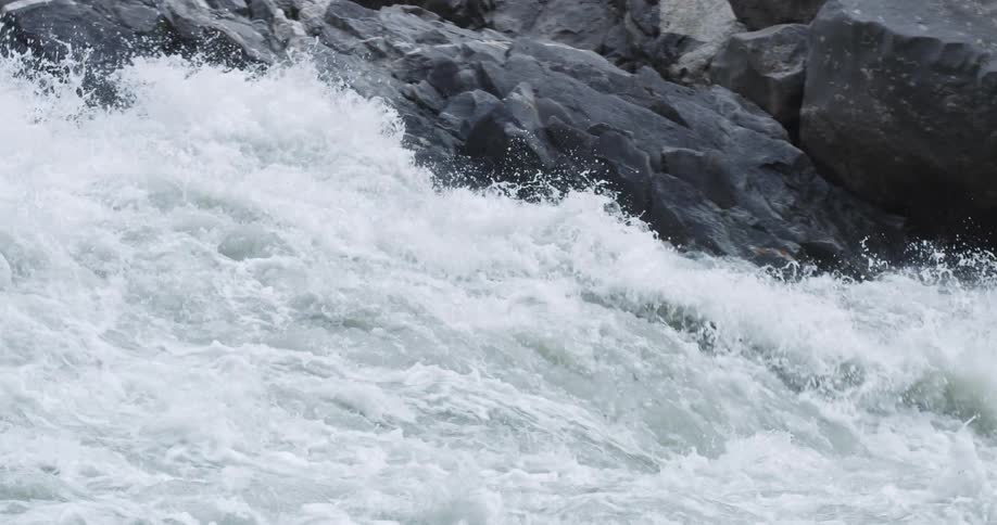 A kayaker attempts to paddle down the rapids of a river