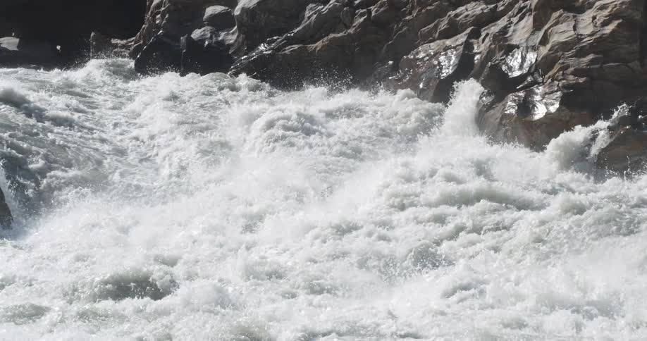 Man rides a kayak on the turbulent waters of a rivers rapids