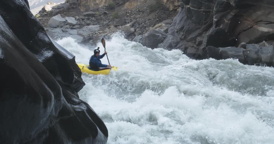 Person navigates kayak through whitewater rapids