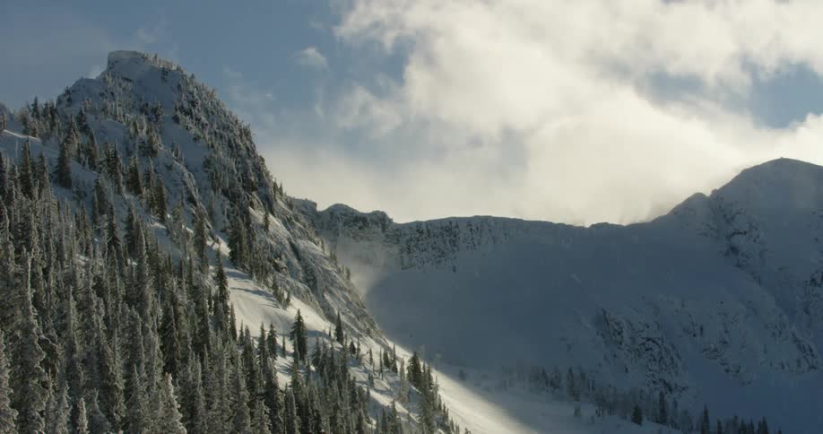 Snowy falls from the sky onto a snowy mountain ridge