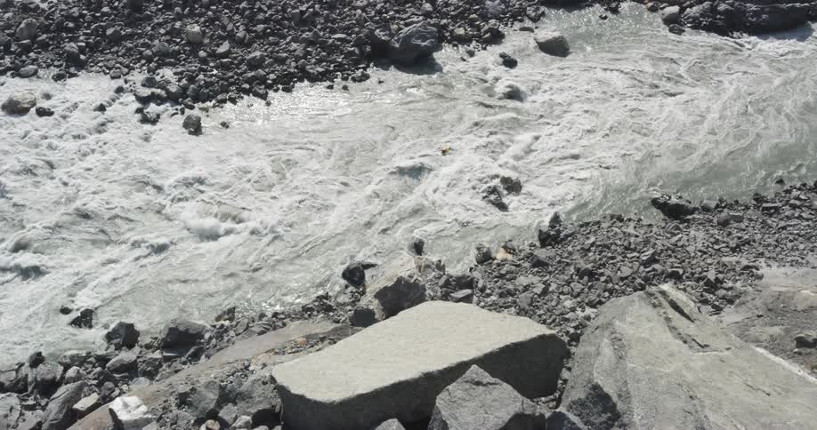 A kayaker enters the stone strewn rapids of a river