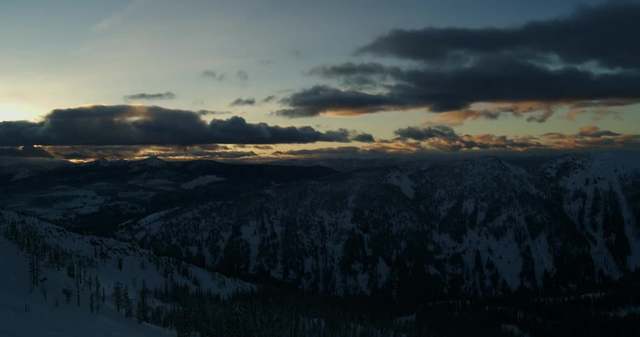 Time lapse of clouds moving over a snowy mountain range