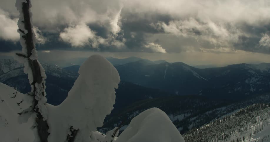 Time lapse of snows rolling over the snow covered mountains