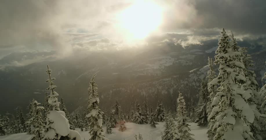 Storm clouds floating over a snowy mountain landscape in the daytime