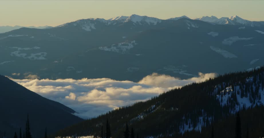 Time lapse of clouds rolling over a valley on the mountains at morning