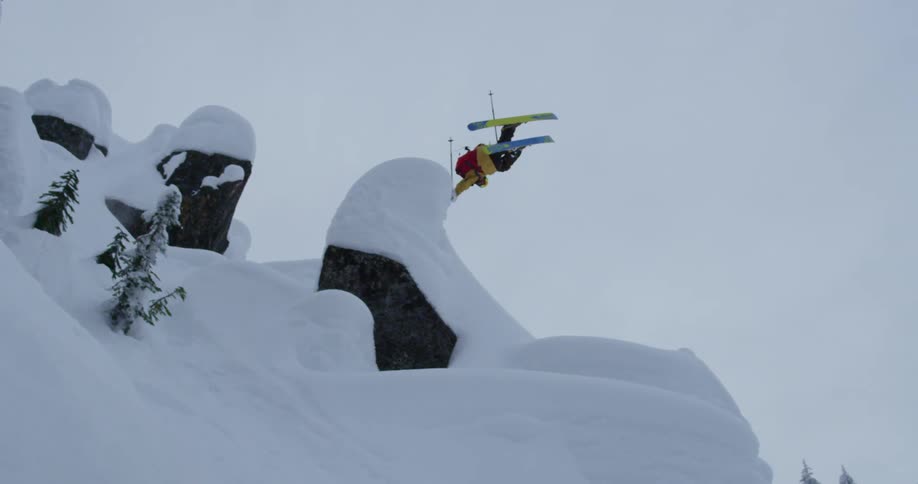 A skier spins and jumps down a steep mountain