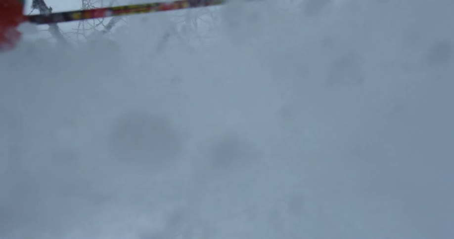 A person on skis in the air as they come down to land in the snow