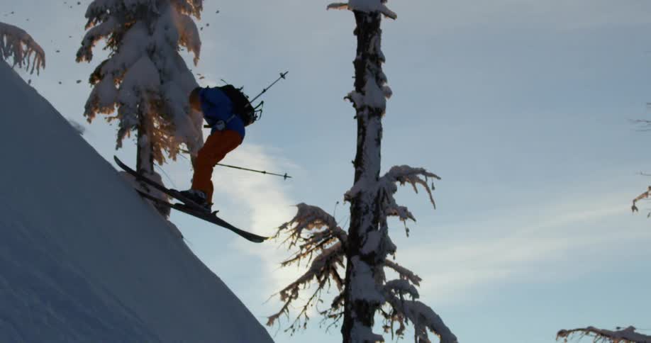A man skiing jumps and turns in the air