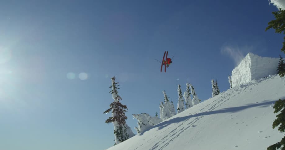 A skier takes off from a rectangle shaped jump and down a steep slope