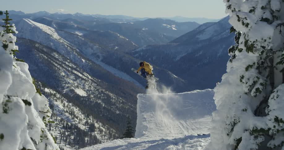 A skier going over a jump in snowy mountains on a winter day