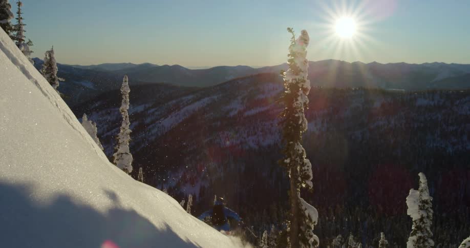 Person on skis does high jump on steep mountainside