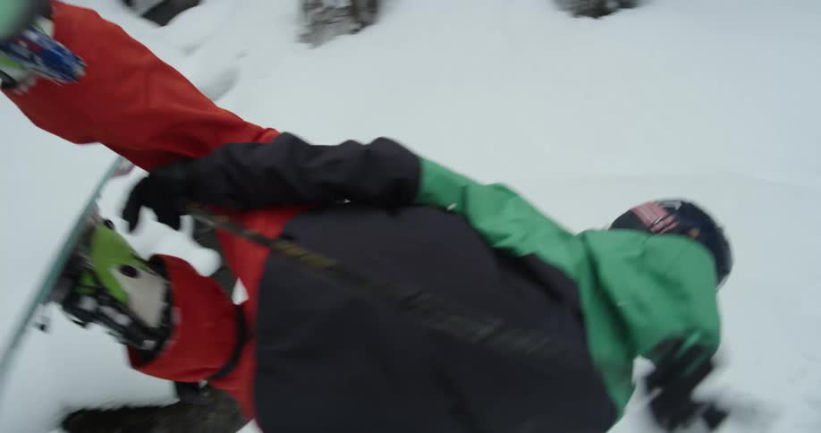 A skier doing a flip over a jump in snowy mountains