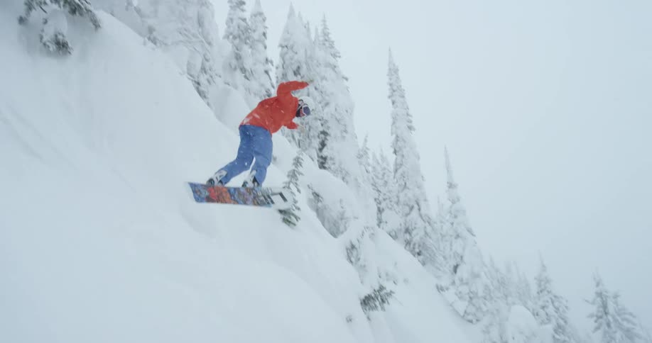 A person is snowboarding down a mountain in winter