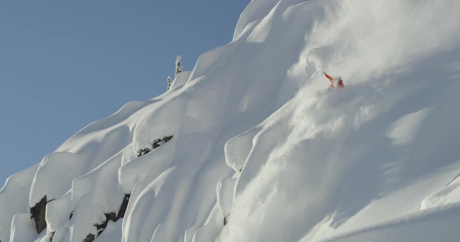 A person snowboarding down a snowy mountain slope