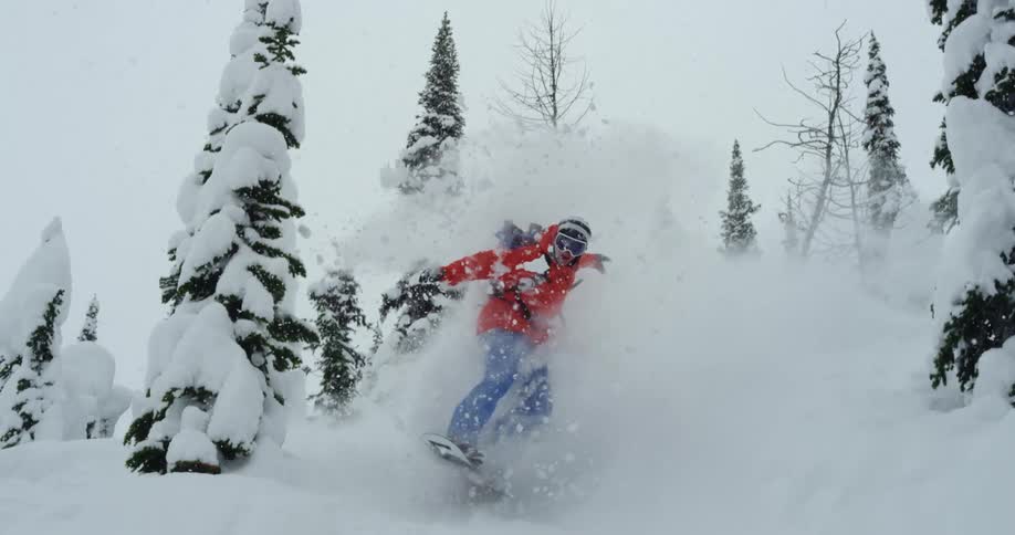 A skier going over a jump in snowy mountains