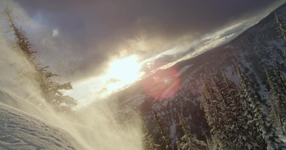 Skier jumps of slope against backdrop ofsnow covered mountain terrain and forest