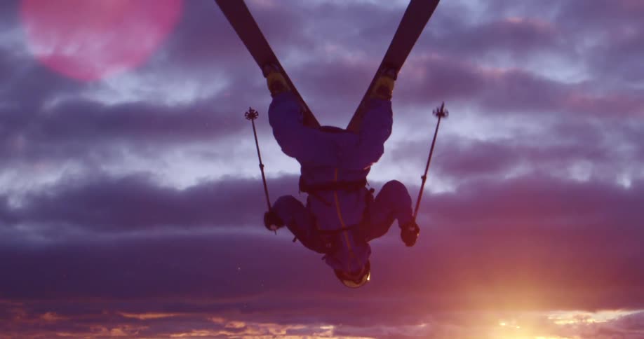 A man skiing jumps and flips in the air