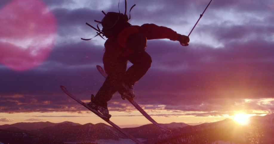 A person skis off the cliff doing a jump