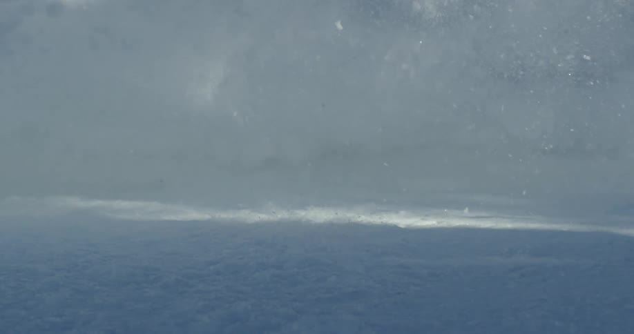 Snow flies as a person skis