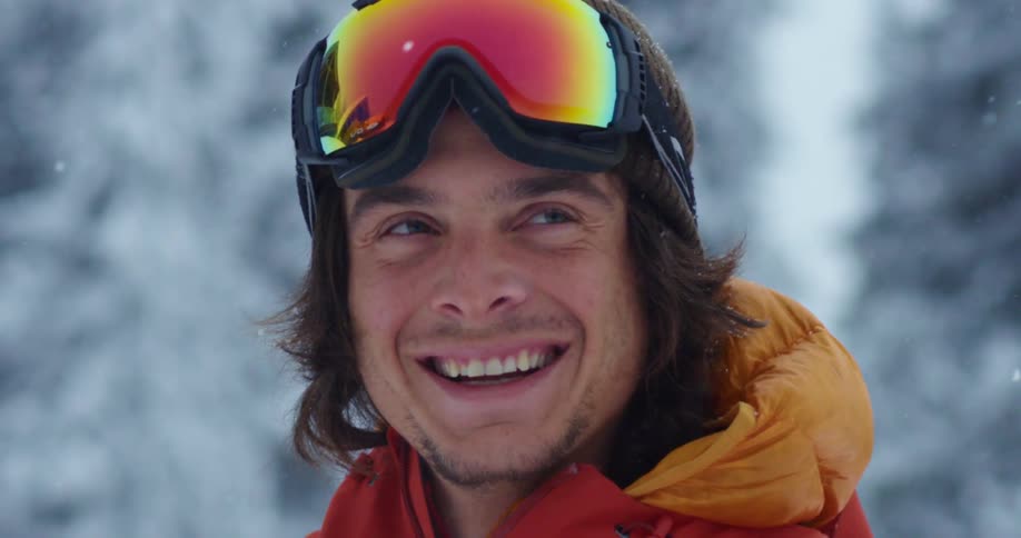 A man is standing outdoors and smiling