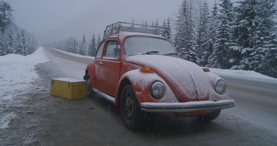 Pulling away from an old orange VW Beetle on the side of a forest road