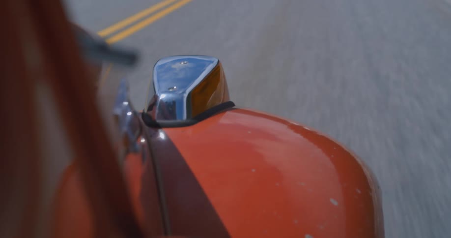 The fender of a vw beetle driving during the day
