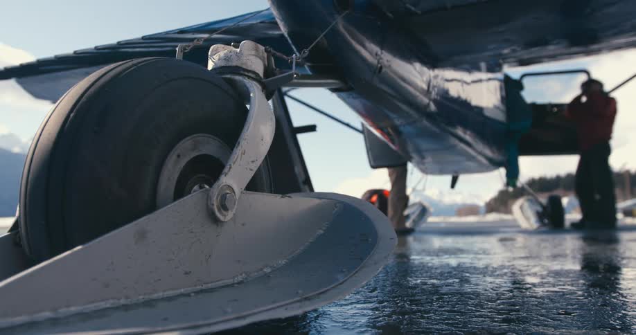 Two people climbing in to a small plane