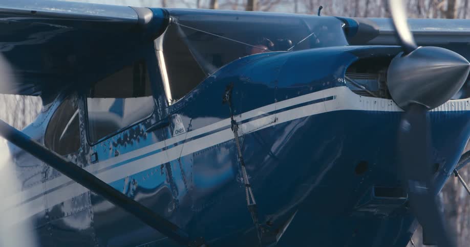 A small plane rotates on the ground on a winter day