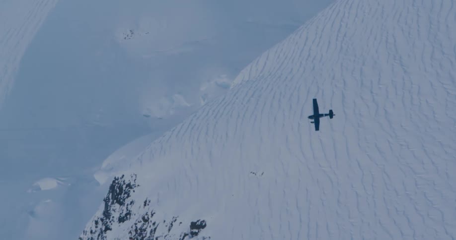 An airplane flying over snowy mountains on a winter day