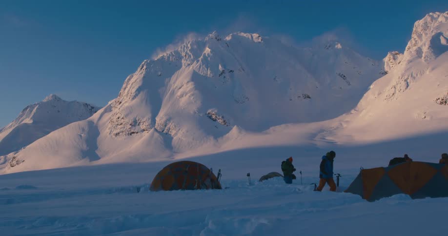 People at their campsite at the base of a mountain