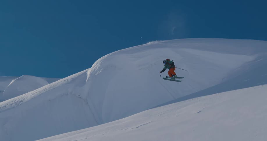 A skier skis down a snow covered hill