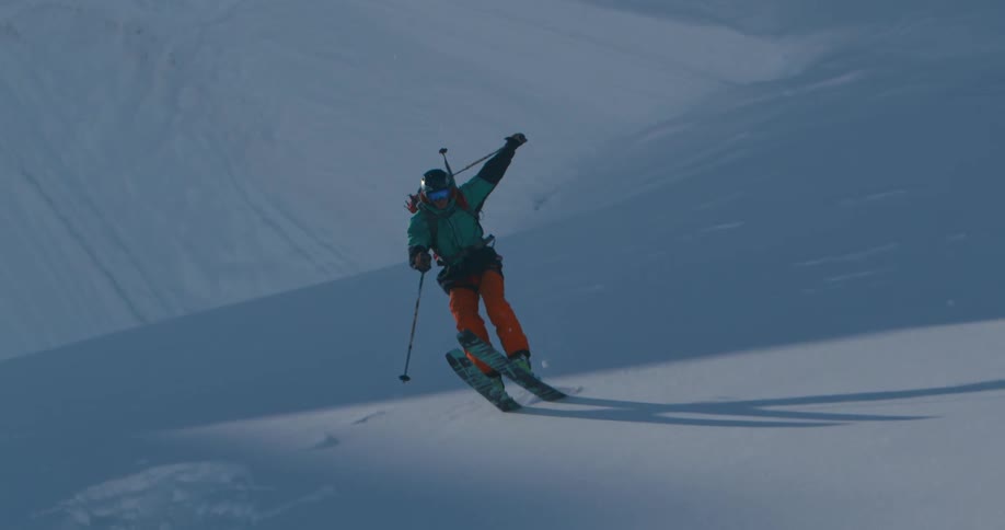 A skier going over a jump in snowy mountains on a winter day